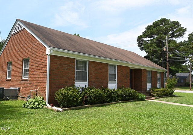 view of front of property featuring central air condition unit and a front lawn