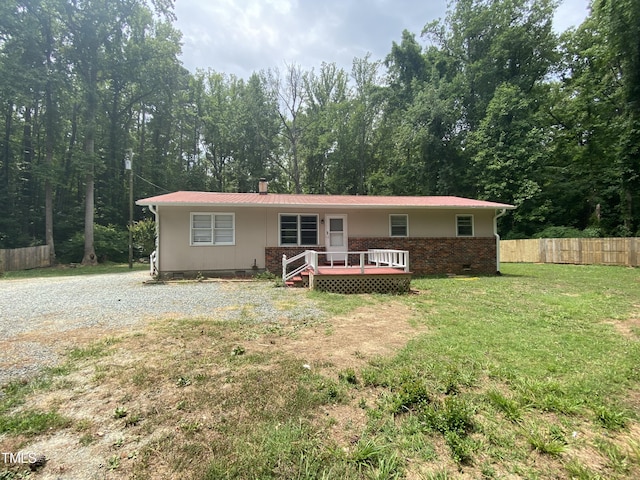 ranch-style home with a wooden deck and a front lawn