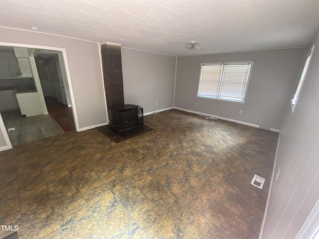 unfurnished living room with a wood stove