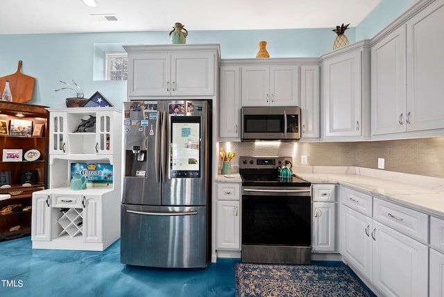 kitchen featuring white cabinets, light stone counters, and stainless steel appliances