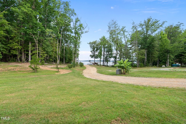 surrounding community with a yard and a water view