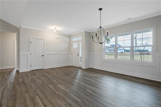 unfurnished dining area featuring ornamental molding, an inviting chandelier, and dark hardwood / wood-style flooring