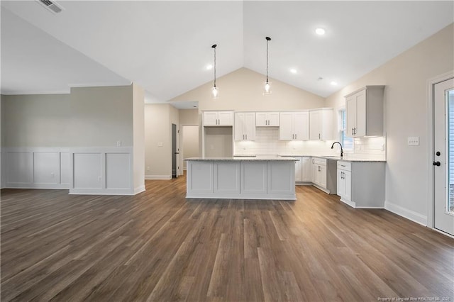 kitchen featuring white cabinetry, decorative backsplash, a kitchen island, decorative light fixtures, and stainless steel dishwasher