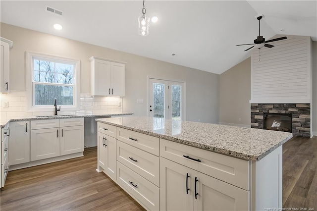 kitchen featuring white cabinetry, sink, hanging light fixtures, and dishwasher