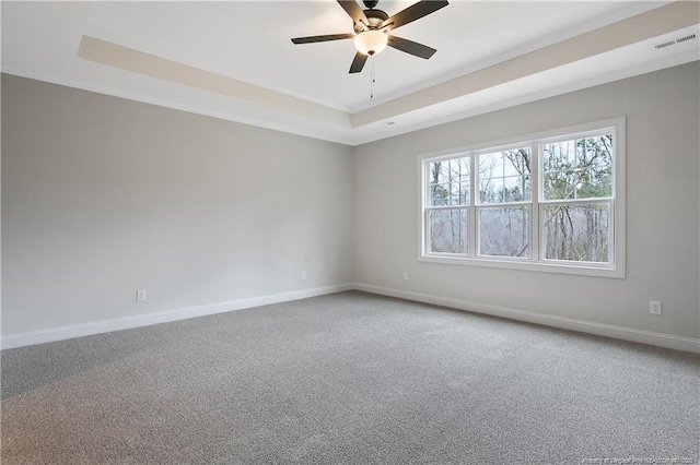 spare room featuring ceiling fan, a tray ceiling, and carpet floors