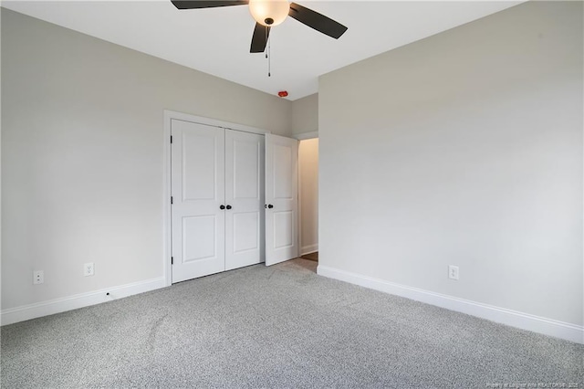 unfurnished bedroom featuring ceiling fan, carpet flooring, and a closet