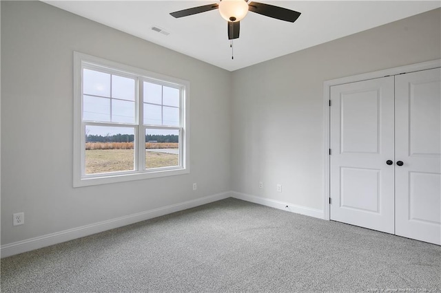 carpeted spare room with ceiling fan