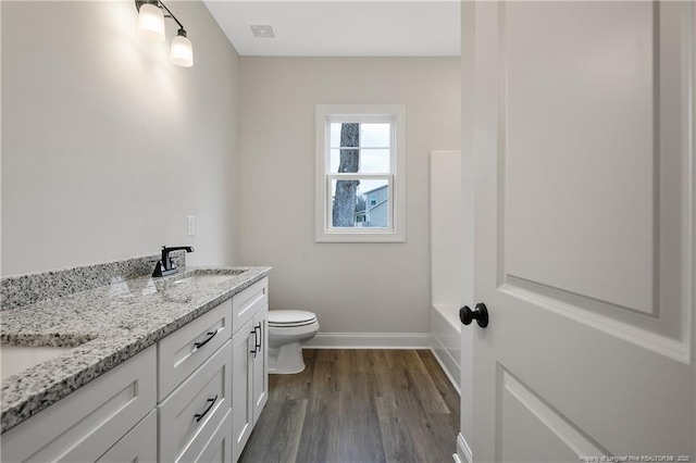 bathroom featuring vanity, hardwood / wood-style flooring, and toilet