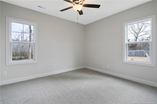 carpeted spare room featuring ceiling fan