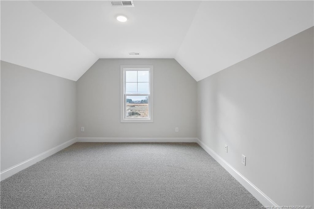 additional living space with vaulted ceiling and carpet floors