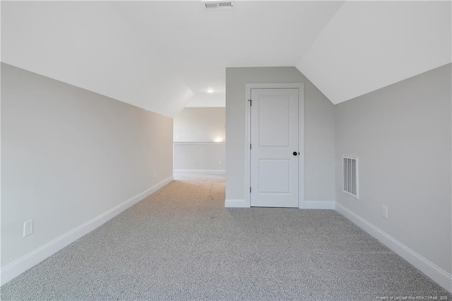 additional living space with light colored carpet and lofted ceiling