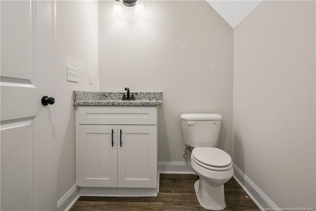 bathroom with hardwood / wood-style flooring, vanity, and toilet