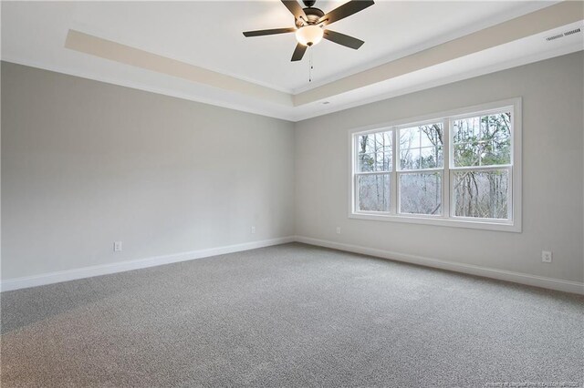 1237 Joe Hall Rd, Hope Mills, NC 28348 - spare room with a tray ceiling, baseboards, light colored carpet, and a ceiling fan