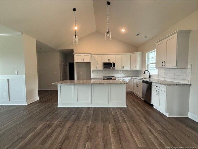 1237 Joe Hall Rd, Hope Mills, NC 28348 - kitchen featuring appliances with stainless steel finishes, white cabinets, a center island, dark wood-style floors, and decorative backsplash