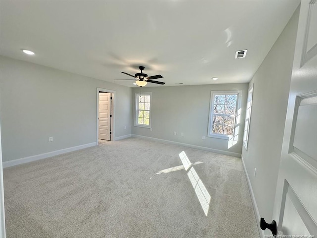 empty room featuring ceiling fan and light carpet