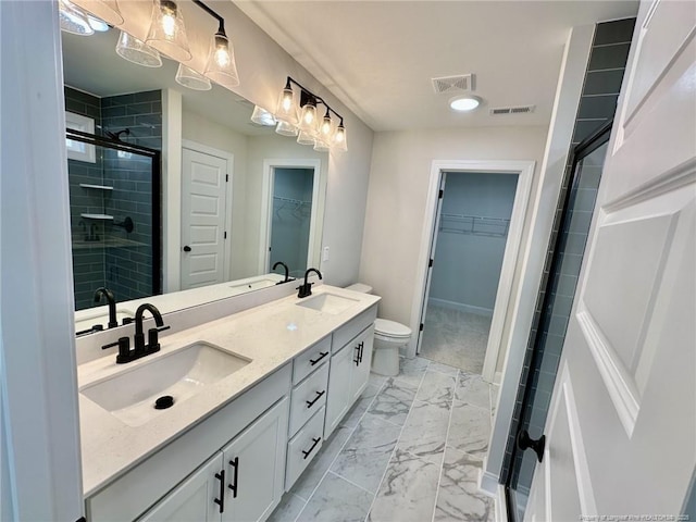 bathroom with a shower with door, vanity, and toilet