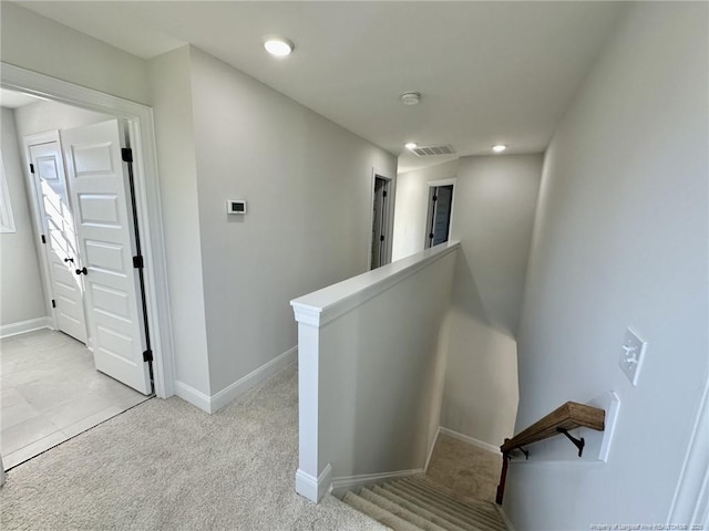 hall featuring light colored carpet