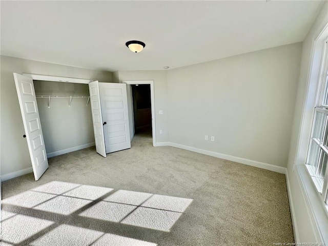 unfurnished bedroom featuring multiple windows, a closet, and light carpet