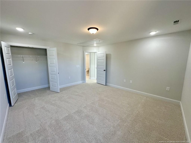 unfurnished bedroom with light carpet and a closet