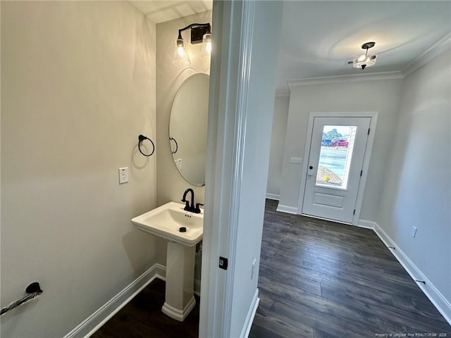 bathroom with hardwood / wood-style flooring, ornamental molding, and sink