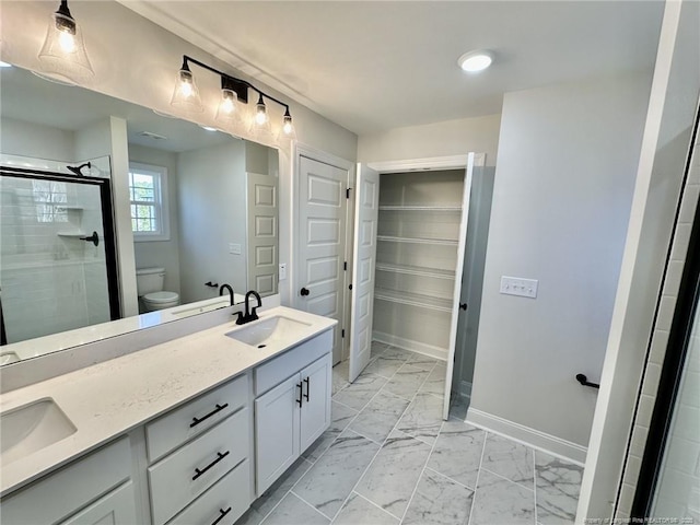 bathroom featuring vanity, toilet, and a shower with shower door