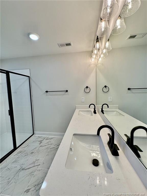 bathroom with a shower with door and vanity