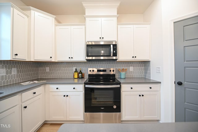 kitchen featuring white cabinets, decorative backsplash, and stainless steel appliances