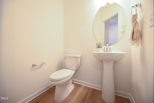 bathroom with hardwood / wood-style floors and toilet