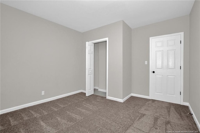 unfurnished bedroom featuring a closet and dark colored carpet