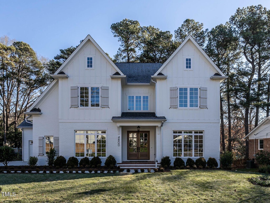 view of front of property featuring a front yard, french doors, and central AC