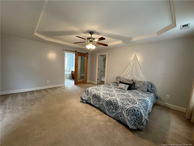 bedroom with ensuite bath, ceiling fan, a raised ceiling, a barn door, and carpet floors