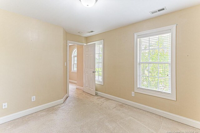 carpeted spare room featuring plenty of natural light