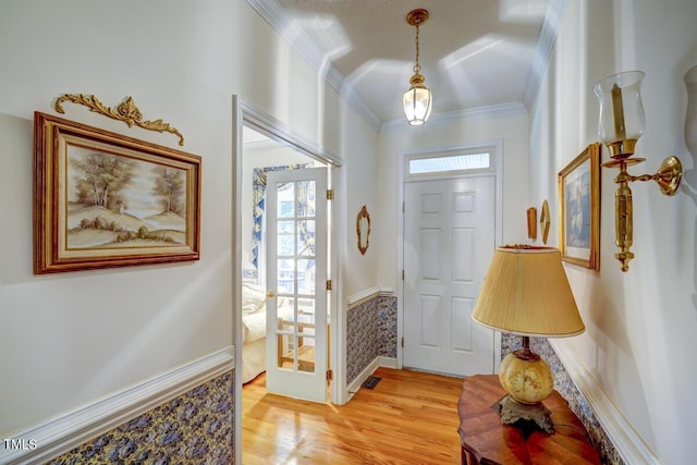 foyer entrance with crown molding and light wood-type flooring