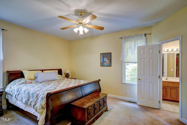 carpeted bedroom with connected bathroom, ceiling fan, sink, and a textured ceiling