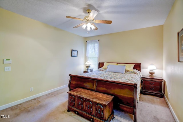 carpeted bedroom with ceiling fan and a textured ceiling