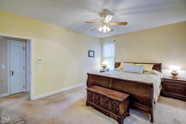 bedroom featuring a textured ceiling, ceiling fan, and light carpet