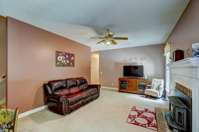 carpeted living room with a textured ceiling, a wood stove, ceiling fan, and lofted ceiling