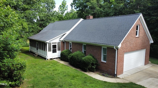 view of front facade with a front yard, a garage, and a sunroom