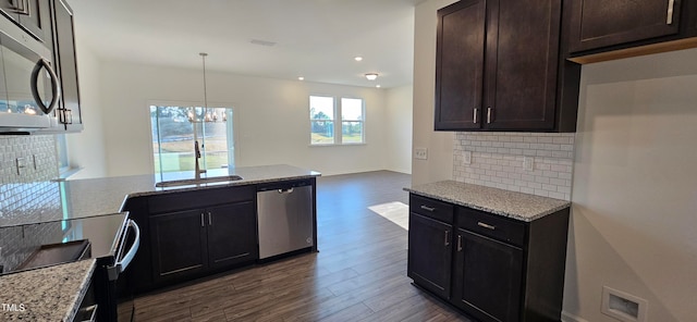 kitchen featuring light stone counters, appliances with stainless steel finishes, dark hardwood / wood-style floors, and sink