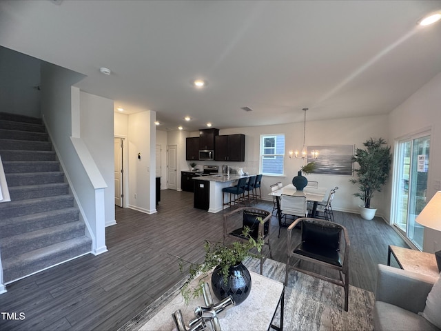 living room with dark hardwood / wood-style floors and a notable chandelier