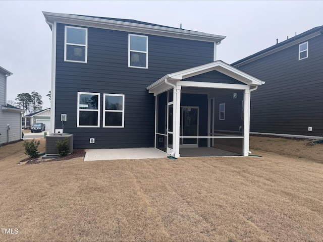 rear view of house featuring central AC unit, a yard, a sunroom, and a patio