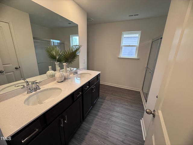 bathroom featuring a shower with door, wood-type flooring, a healthy amount of sunlight, and vanity