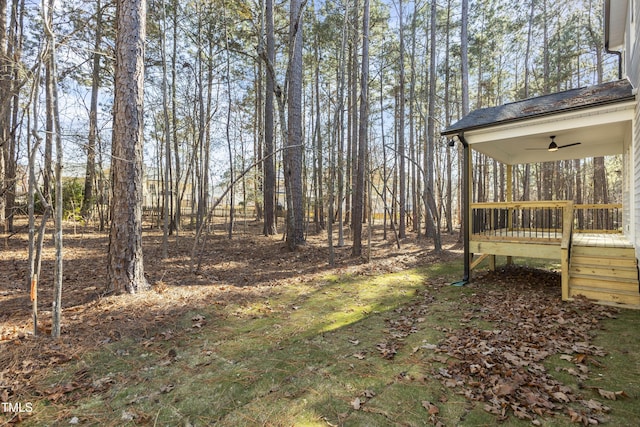 view of yard featuring a wooden deck and ceiling fan