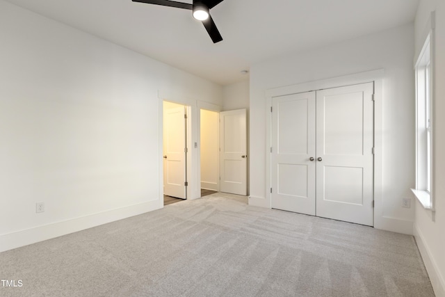 unfurnished bedroom featuring a closet, ceiling fan, and light colored carpet