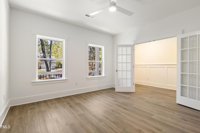 spare room featuring ceiling fan, wood-type flooring, and french doors