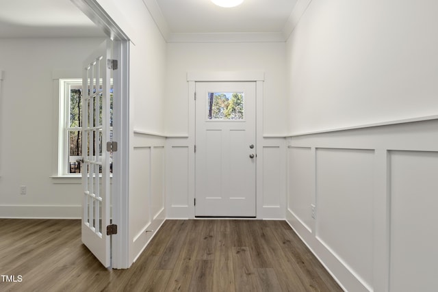 entryway featuring dark wood-type flooring, a wealth of natural light, and ornamental molding