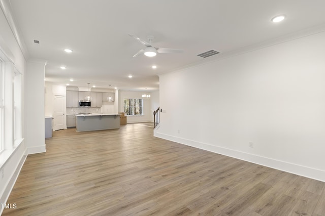 unfurnished living room featuring ceiling fan, light hardwood / wood-style floors, and ornamental molding