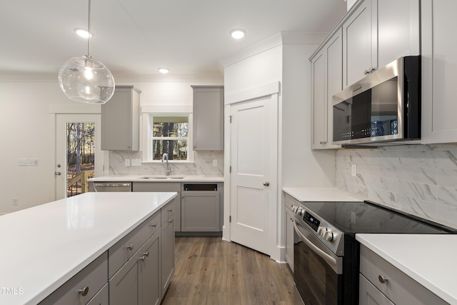 kitchen with decorative light fixtures, stainless steel appliances, gray cabinetry, and sink