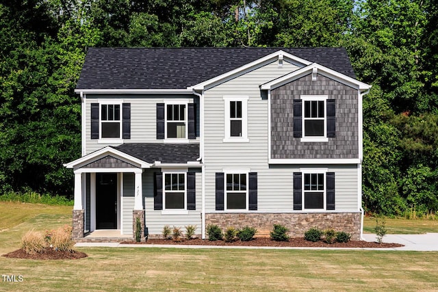 craftsman inspired home featuring a front yard, stone siding, and a shingled roof