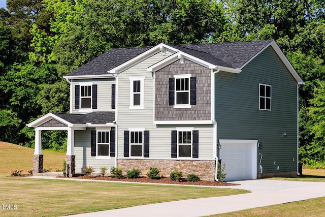 view of front facade featuring driveway, a front yard, a garage, and roof with shingles